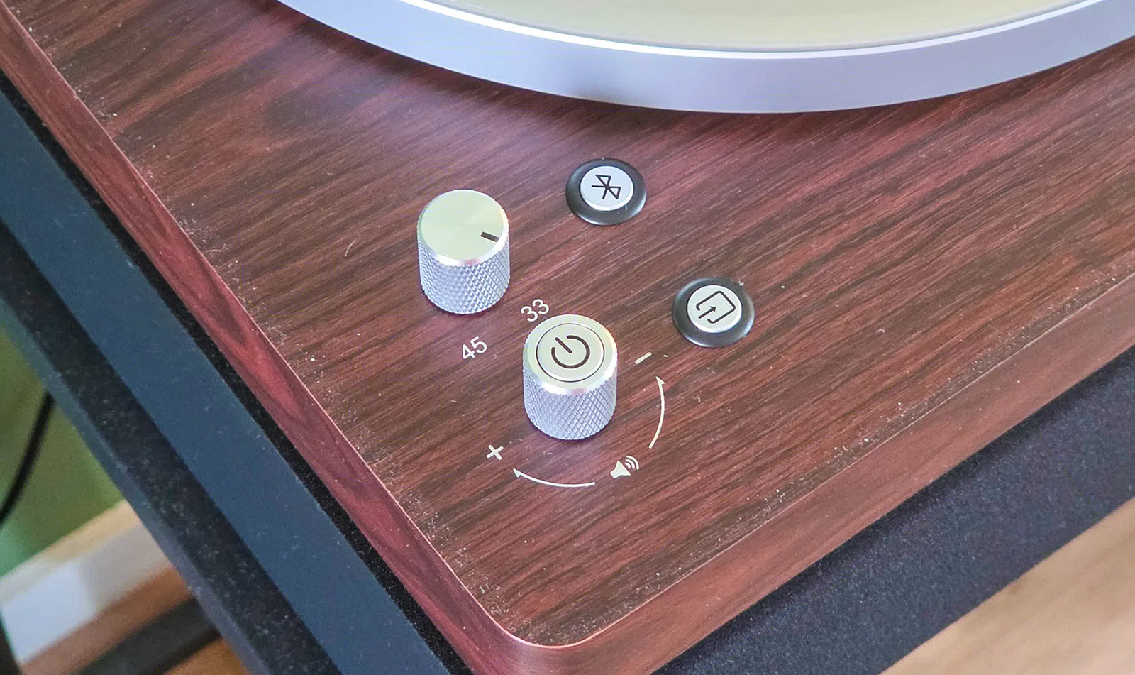 Close-up van de bediening van de Aulo: volumeknop, snelheid 33 en 45 toeren, aan/uit en de Bluetooth-knop