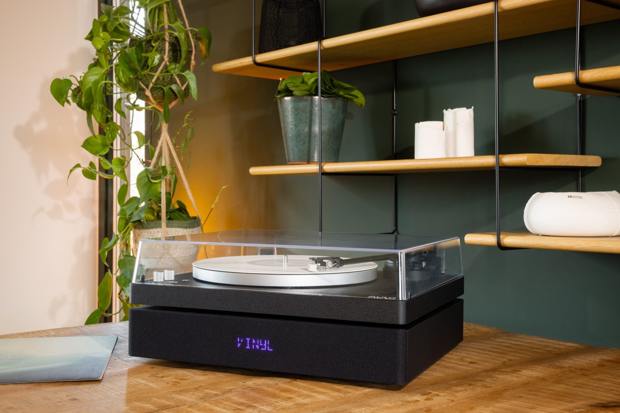 Aulo platenspeler met VINYL-display in een modern interieur met planten en houten rekken