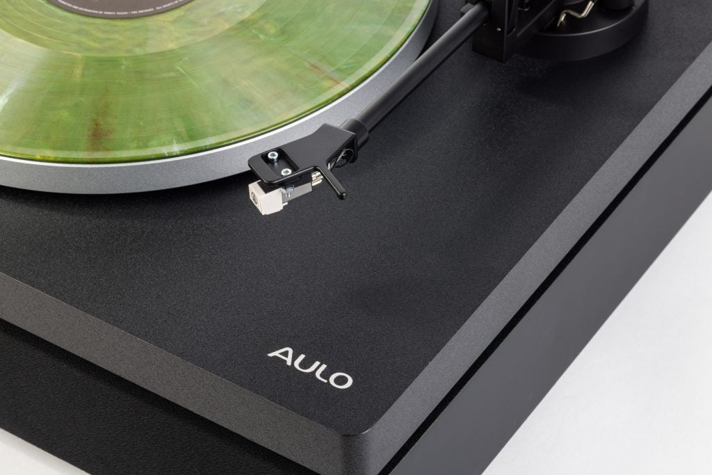 Close-up van de arm en het element van de Aulo op een groene vinylplaat, matte zwarte afwerking